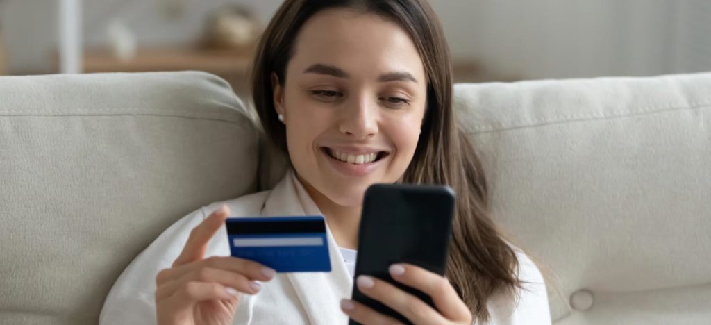 a happy woman making digital payment through card