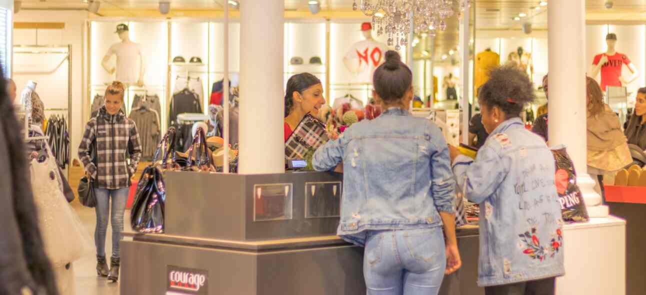 Girls paying their bill in a store counter