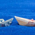 Two paper boats made of two different currency notes to represent cross border payments